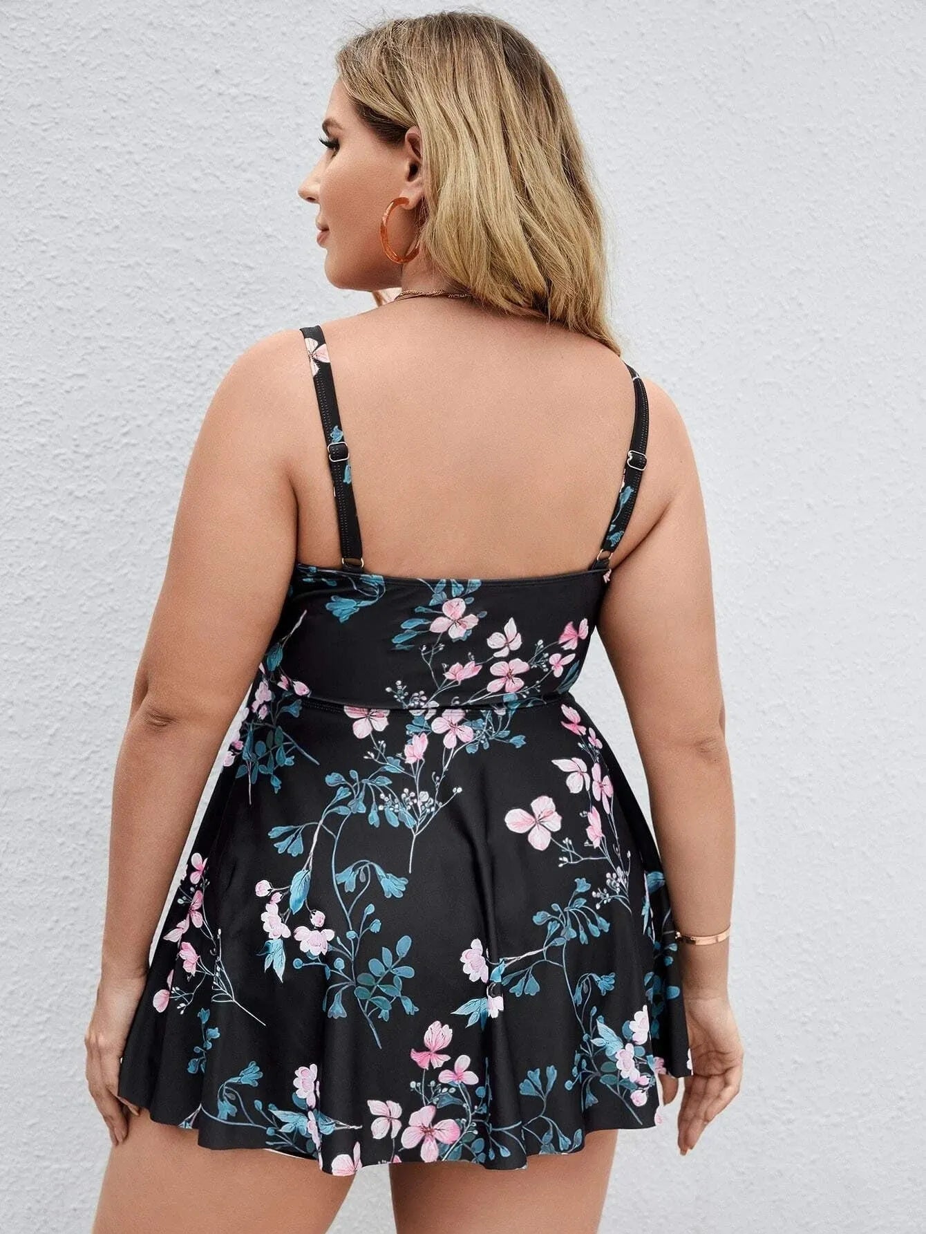 Women's floral print one-piece swimsuit on hanger, showing split colour design and high-elasticity polyester fabric.