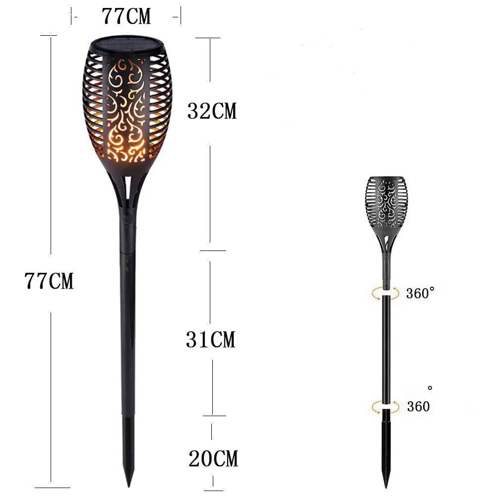 LED solar flame flickering lawn lamp with 96 warm white LEDs, black finish, inserted into grass with realistic dancing flame glow at night