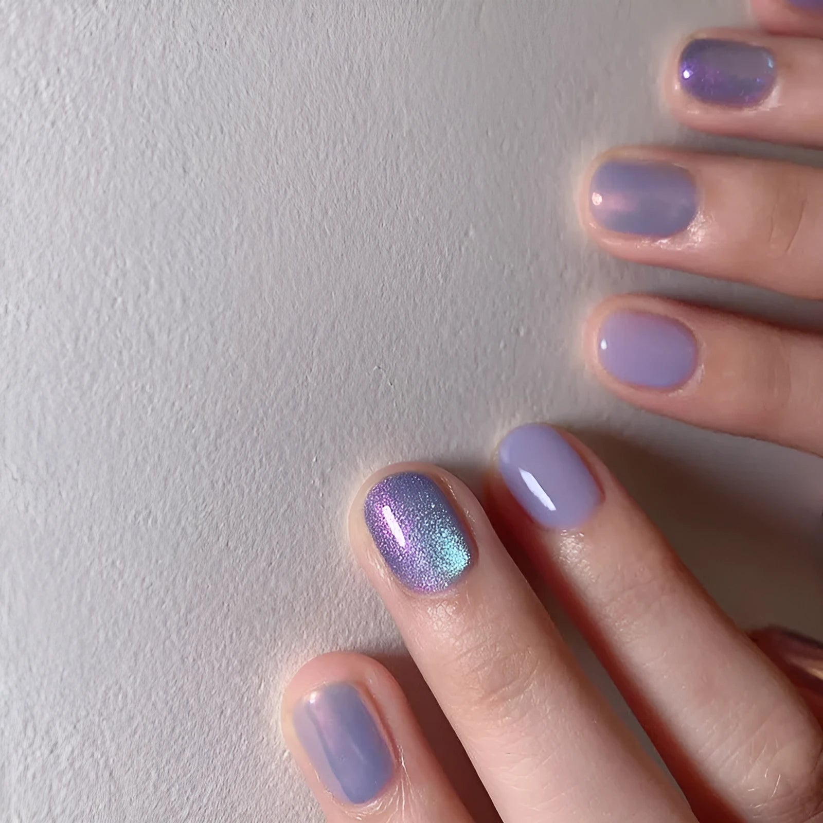 Short false nails with bright Aurora starry sky pattern and included glue tube.