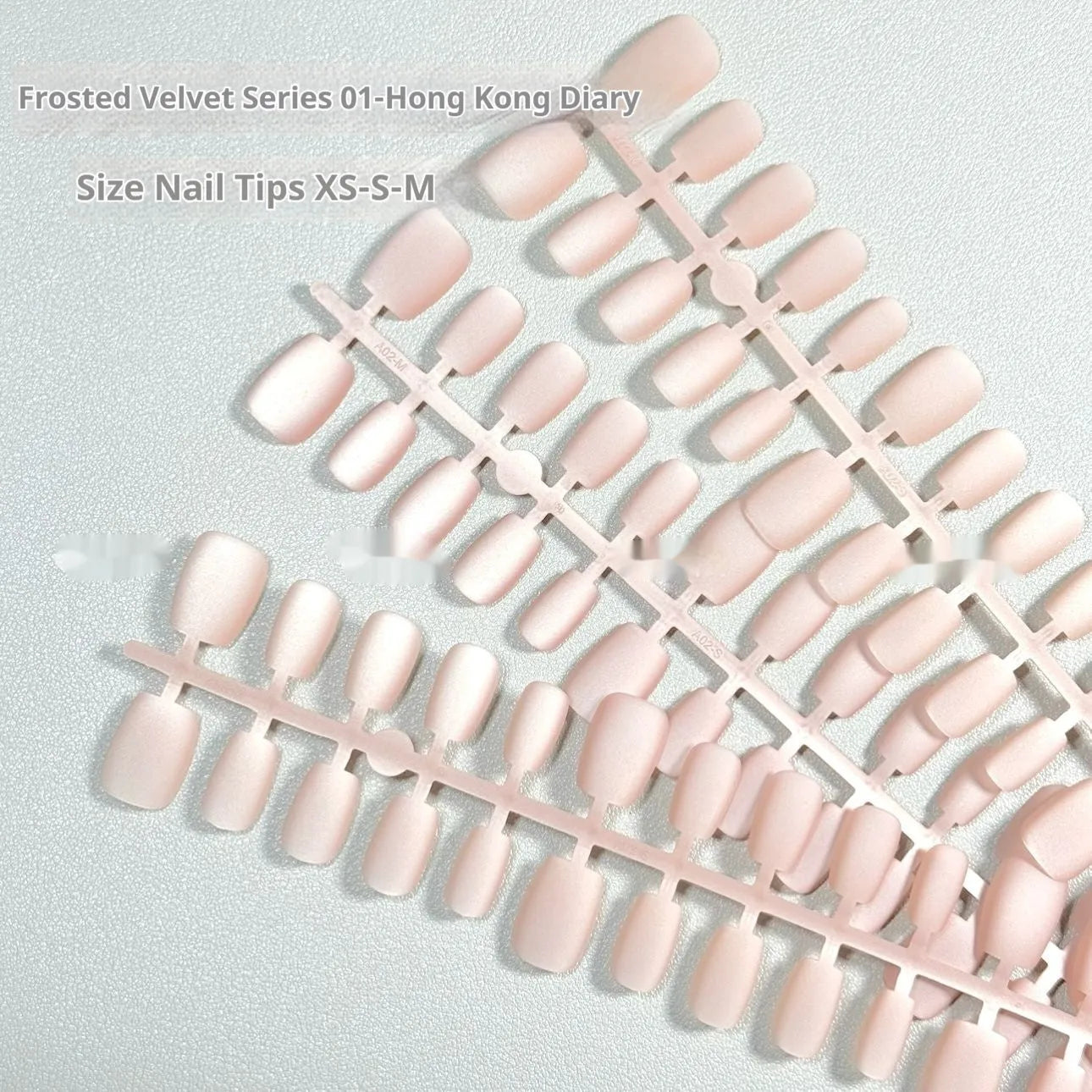 Set of frosted velvet false nails with Cat's Eye effect in short ladder sizes XS, S, and M.