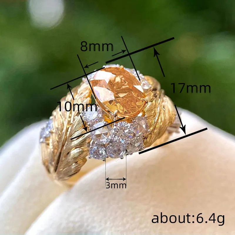 Gold-coloured embossed feather ring with geometric design and yellow zircon stone