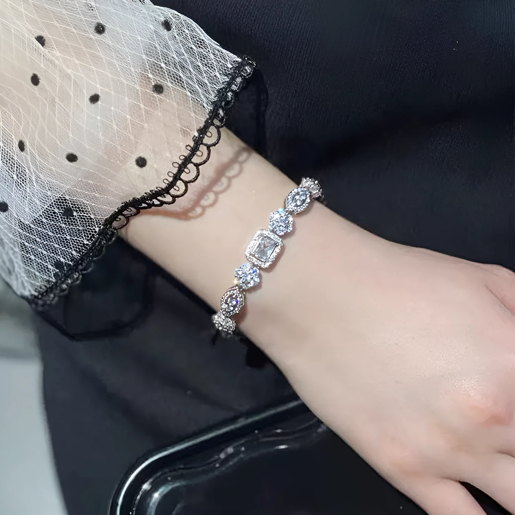 Women's geometric silver-plated bracelet with inlaid zircon stones on a wrist.