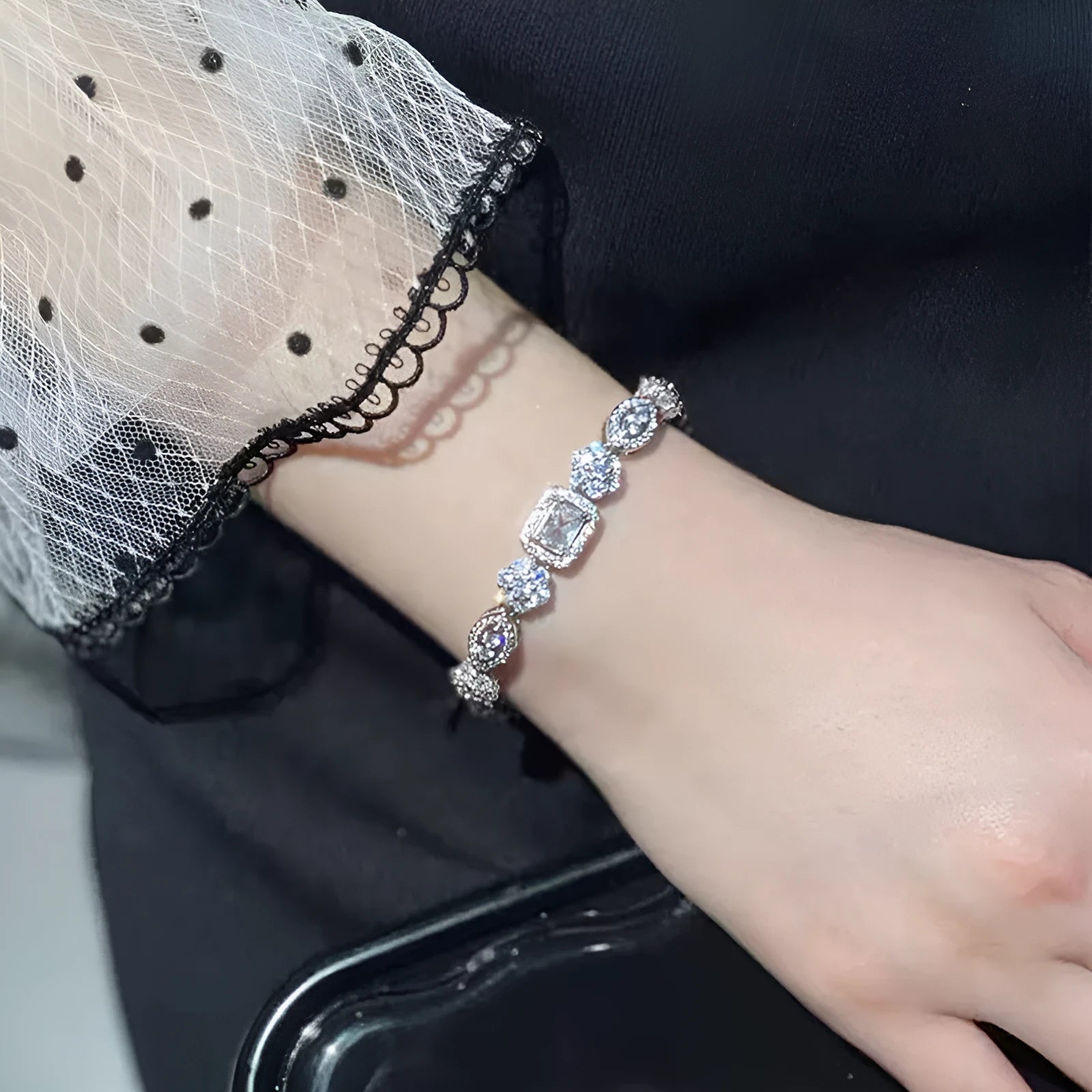 Women's geometric silver-plated bracelet with inlaid zircon stones on a wrist.