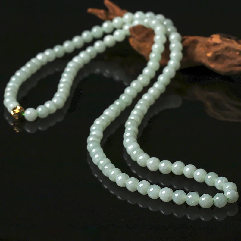 Natural white-green jade bead necklace with adjustable chain and 6.5mm round beads on grey background
