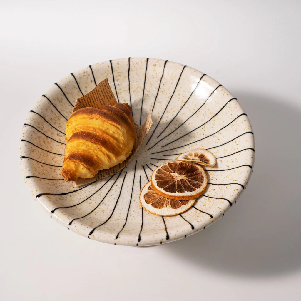Black and white striped synthetic resin fruit plate on a table.