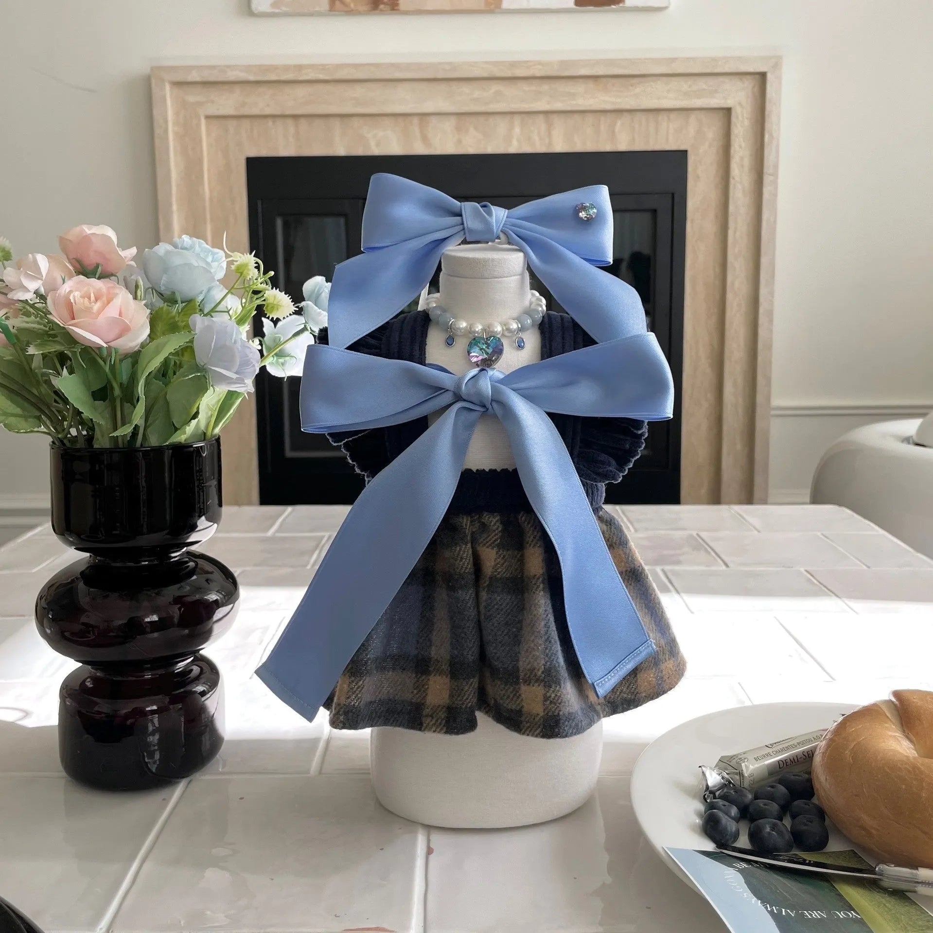 A dog wearing a blue princess style hair band with a large, adjustable bow on its head.
