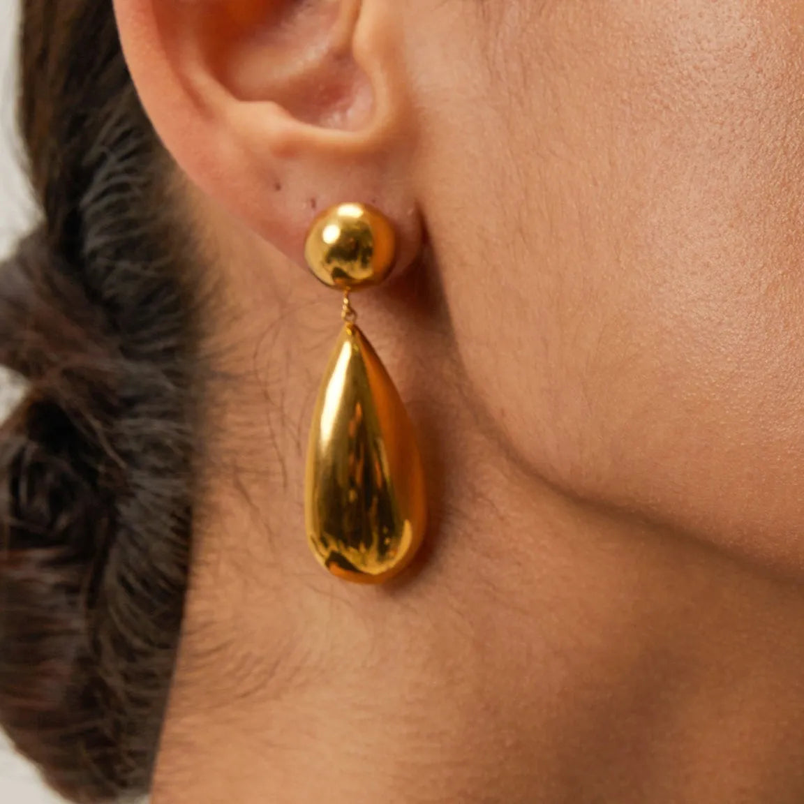 Gold coloured stainless steel earrings with a geometric shape and water drop pendant.