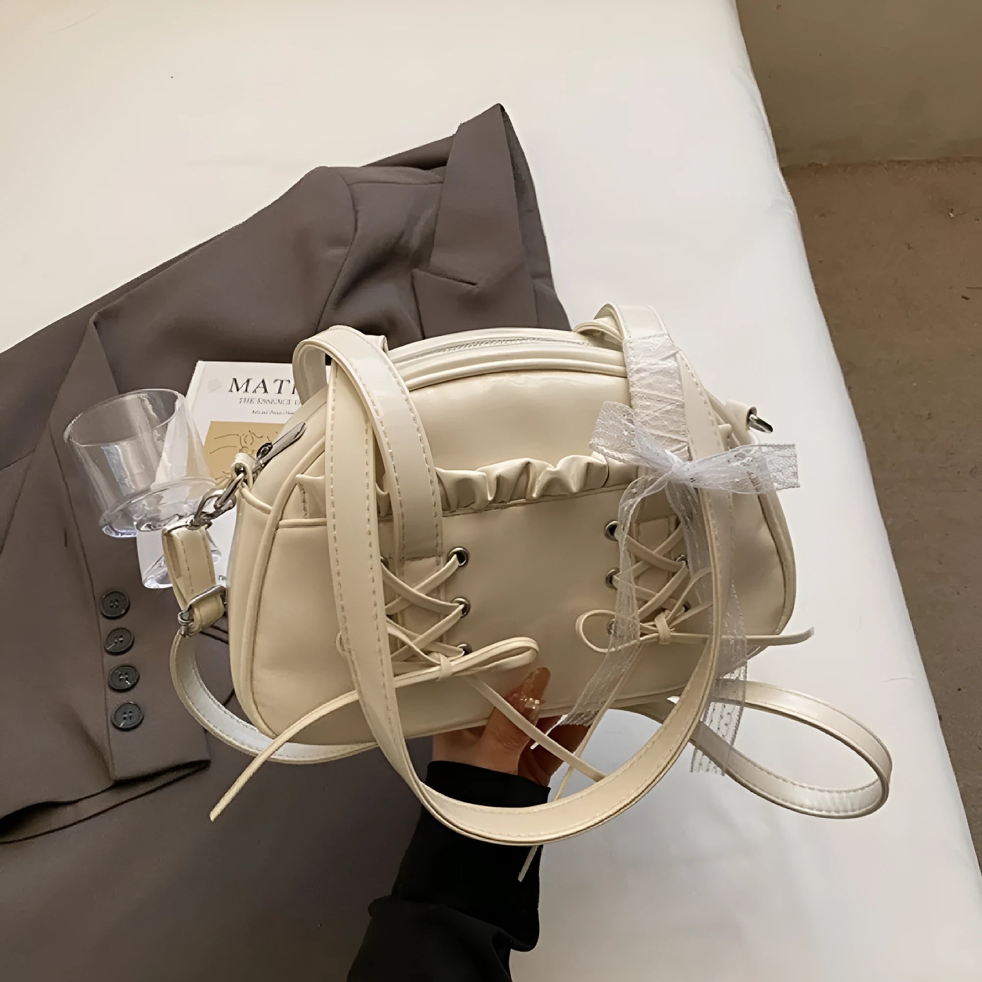 Women's PU leather handbag with bandage bow detail showing internal mobile phone pocket