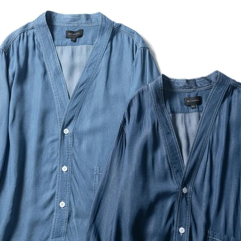 Men's dark blue V-neck denim coat with three-quarter sleeves showing loose fit and pocket detail
