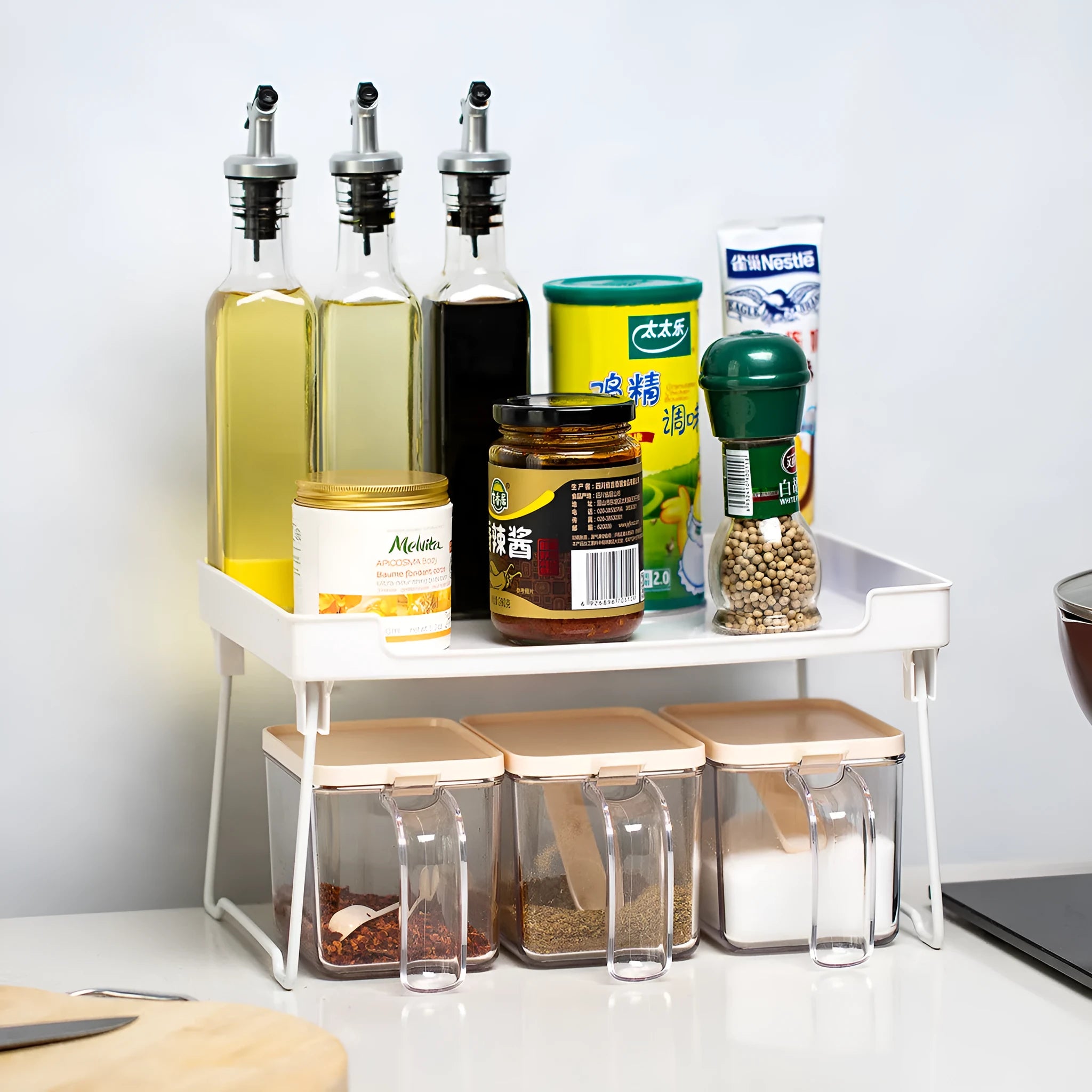 White plastic kitchen supplies rack on a countertop holding spice jars.