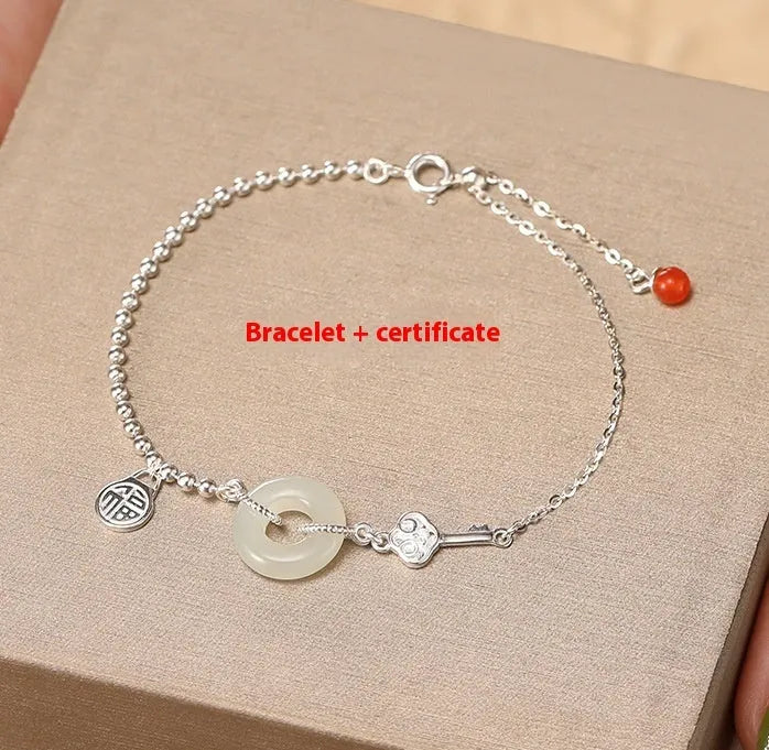 Women's silver bracelet with Hetian jade and a traditional Chinese peace buckle charm on a geometric link chain.