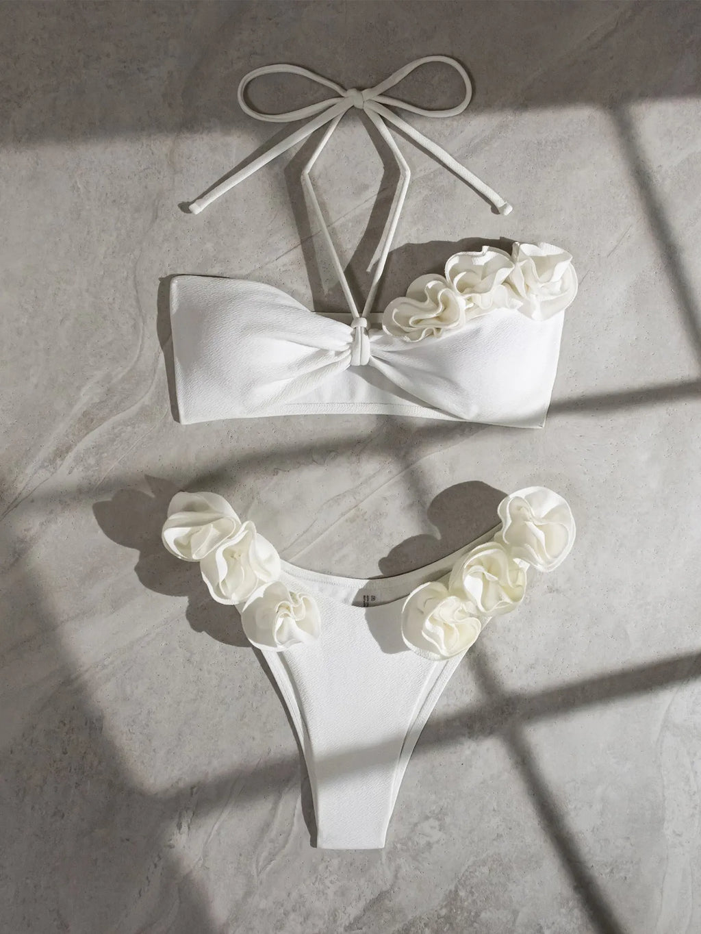 White halter neck lace-up swimsuit with three-dimensional floral details and brief bottom