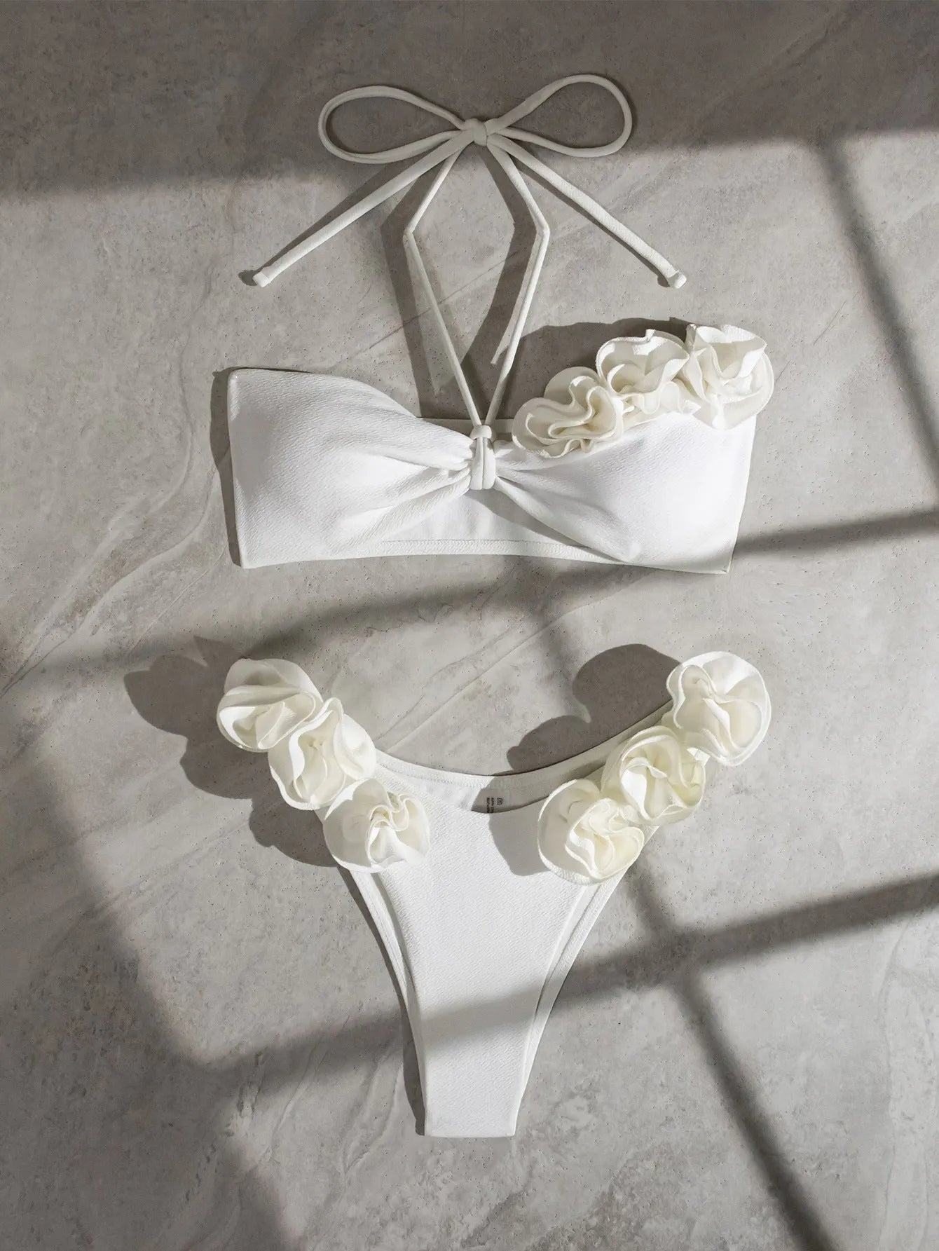 White halter neck lace-up swimsuit with three-dimensional floral details and brief bottom