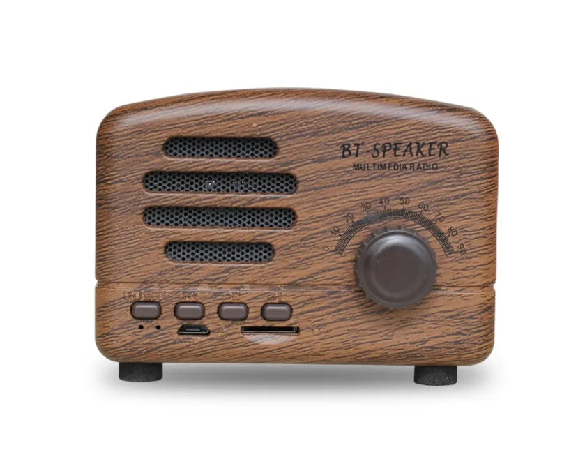 Compact vintage wood style Bluetooth speaker in pink, black, or wood grain finish on a table.