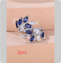Adjustable copper leaf-shaped ring with zircon stone accents on a hand.