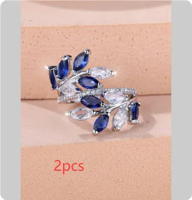 Adjustable copper leaf-shaped ring with zircon stone accents on a hand.