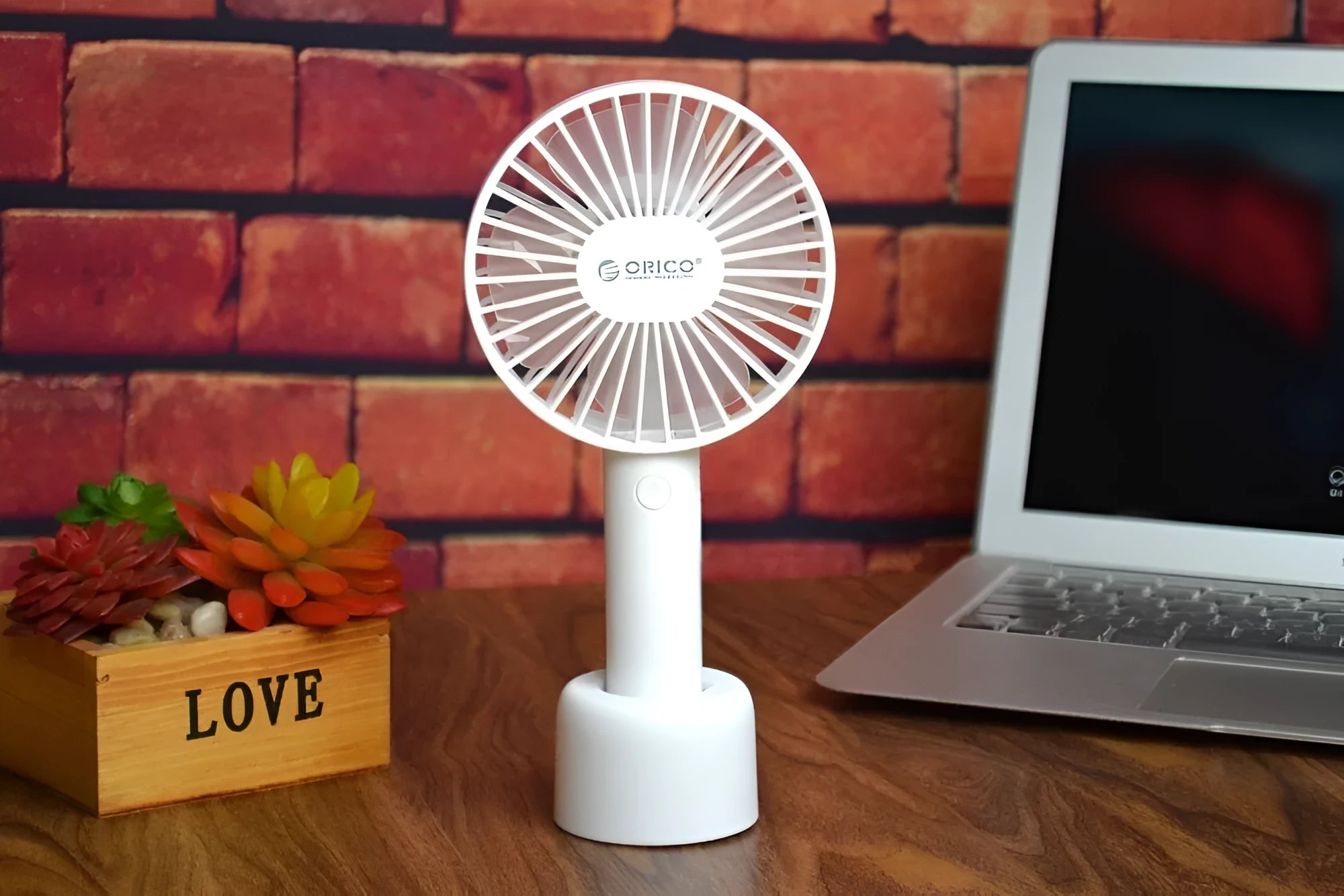 White ORICO FH1 portable USB rechargeable desk and handheld fan on a table