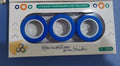 Plastic magnetic finger rotating ring spinner toy shown in multiple colours on a finger.