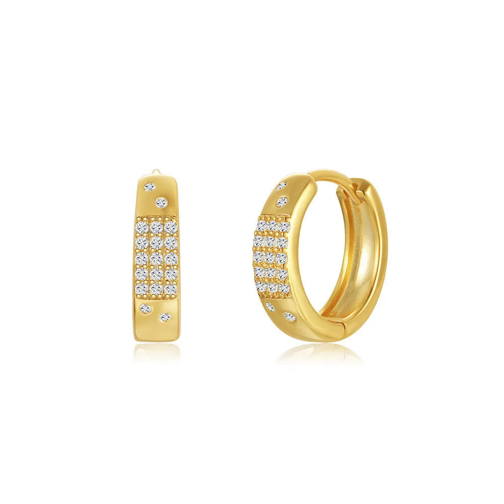 A pair of round, gold-toned brass diamond earclip earrings on a white background.