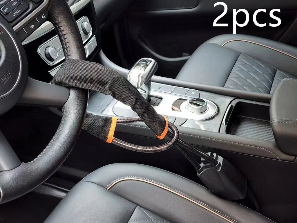 Red car steering wheel lock with steel cable secured on a steering wheel.