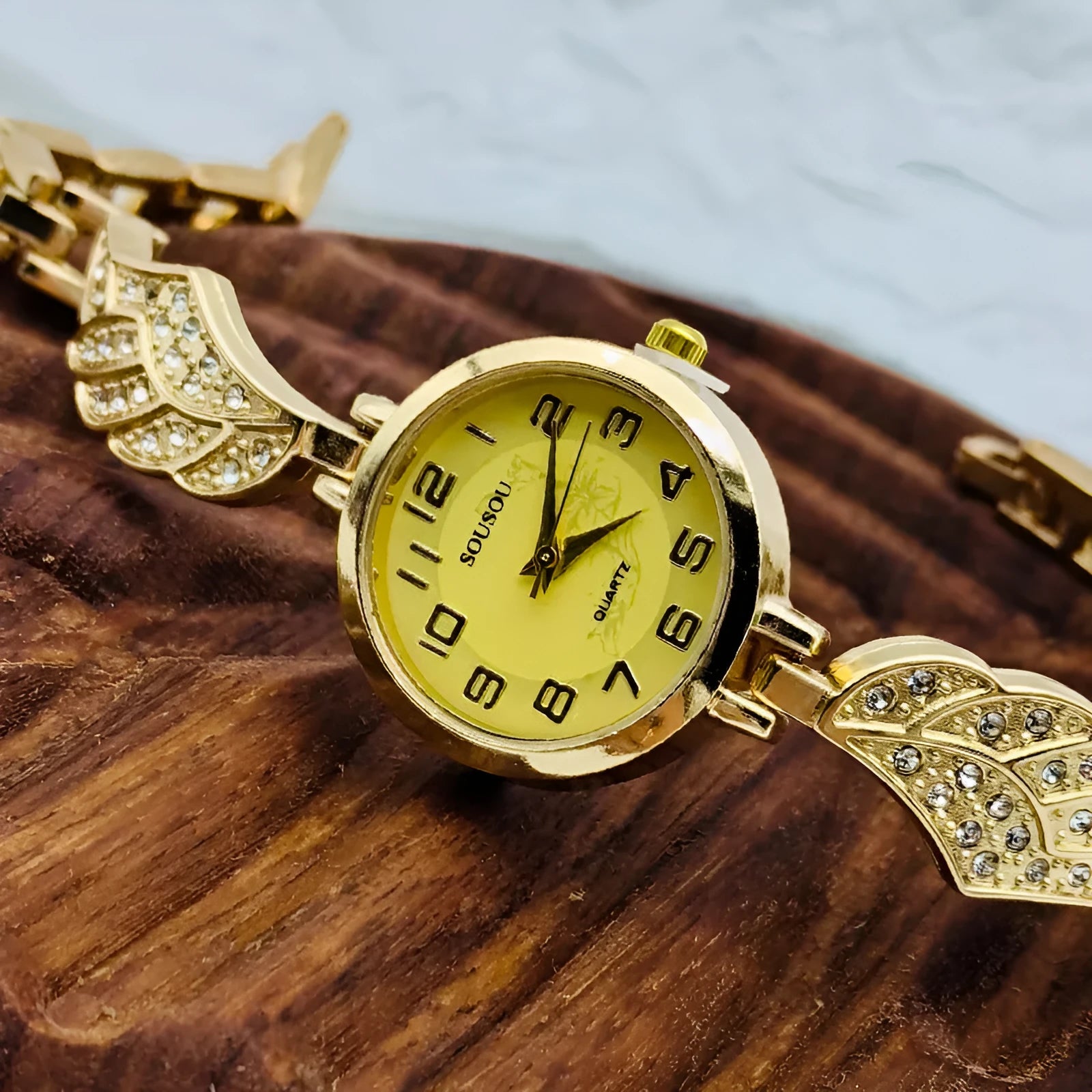 Women's stainless steel watch with round dial showing gold surface and vachette clasp