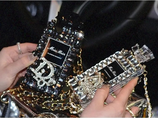 Perfume bottle bow design iPhone case with a metal chain strap in black, gold, pink, or transparent colours.