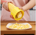 Yellow manual corn thresher with corn-kernel-shaped design on a kitchen counter.