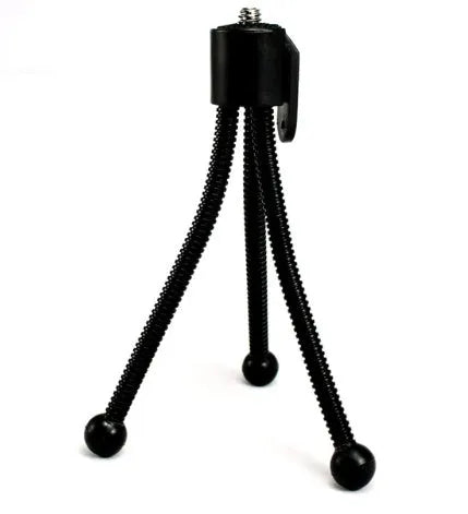 Small iron frame mini desktop tripod with folding legs and a ball head, shown alongside a camera.