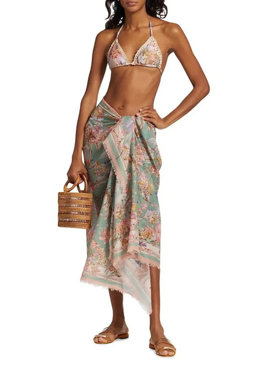 Women's creamy white floral bikini set with top, briefs, and removable skirt on beach background