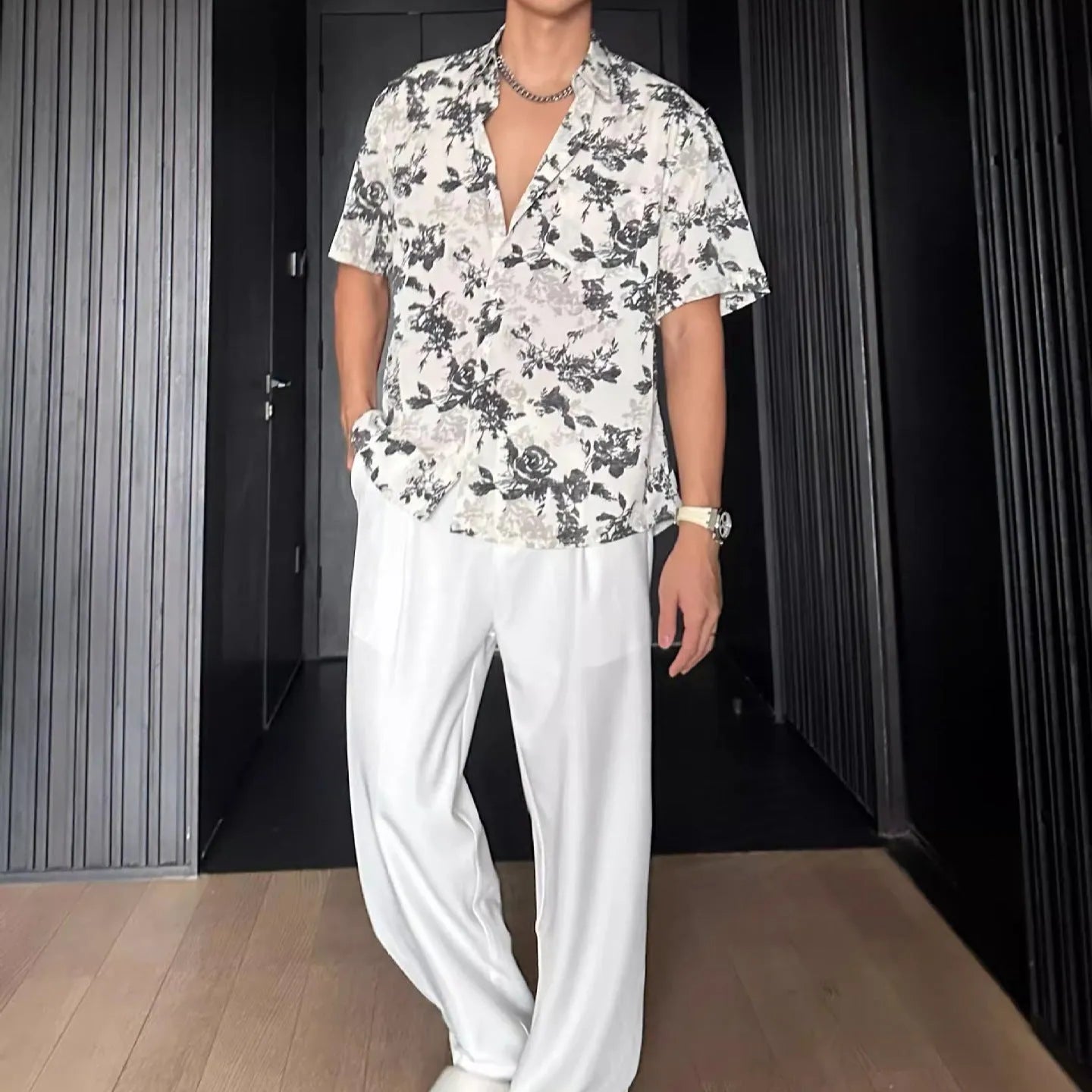 Black and white loose-fit floral printed short sleeve casual shirt on a hanger.
