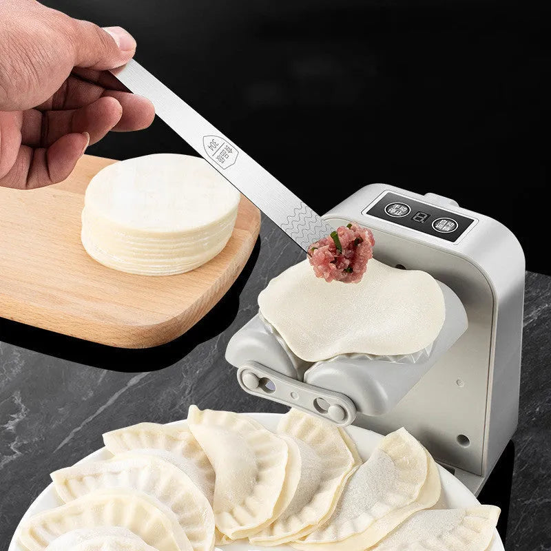 White electric automatic dumpling maker machine with accessories on a kitchen counter.
