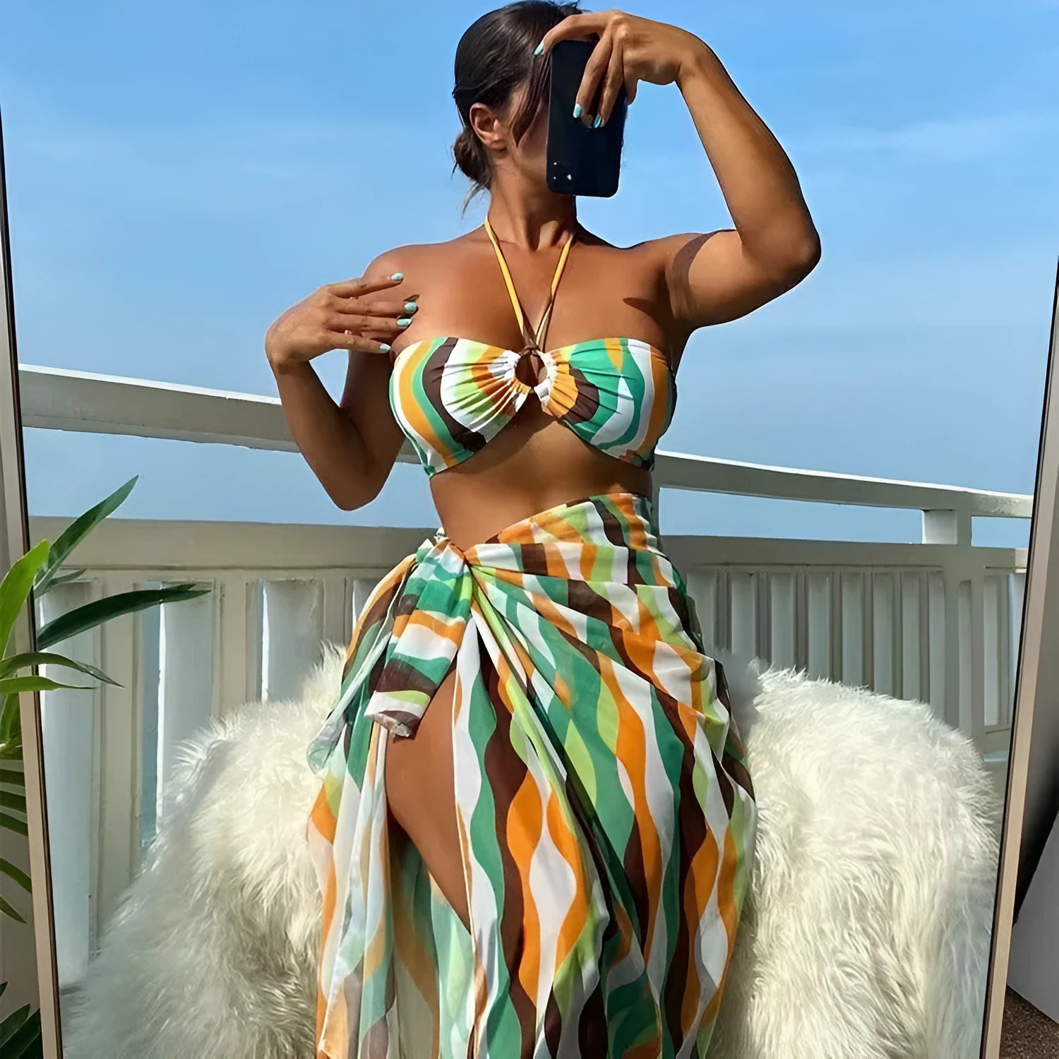 Women's yellow green three-piece swimsuit set with bikini top, briefs, and a printed beach skirt.