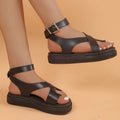 Women's white thick-soled Roman sandals with an ankle buckle fastener on a lace loop.