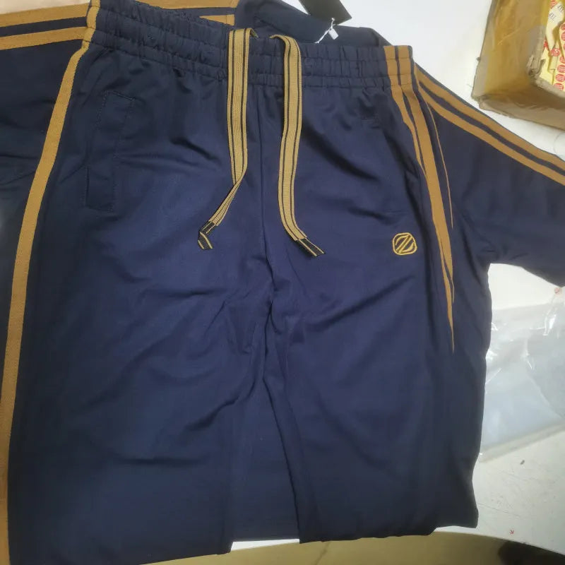 Man wearing a blue short sleeve polyester tracksuit set, showing the matching top and trousers.