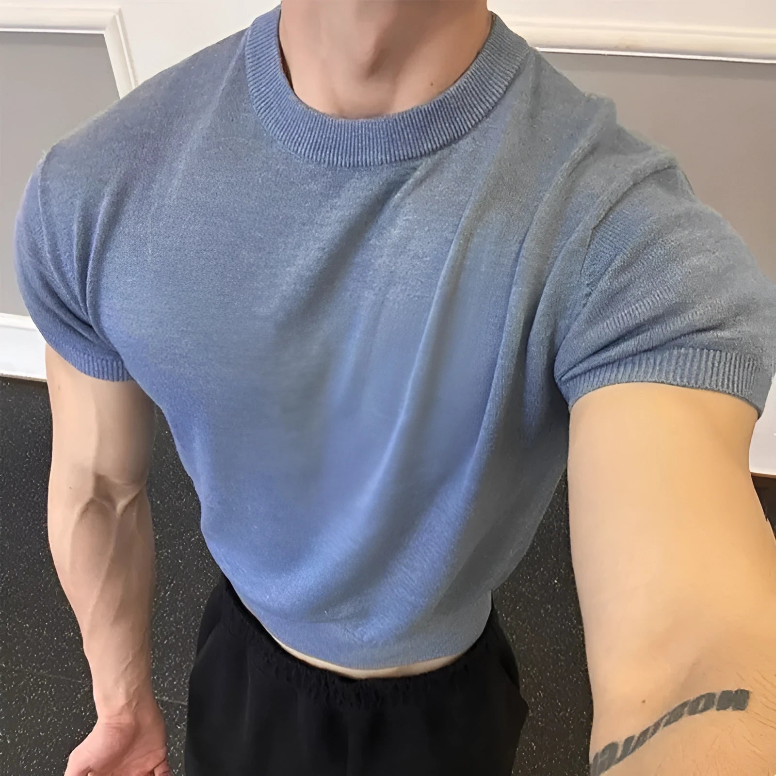 Men's slim fit short sleeve polyester T-shirt showing cuff-closing thread detail in solid colour option.
