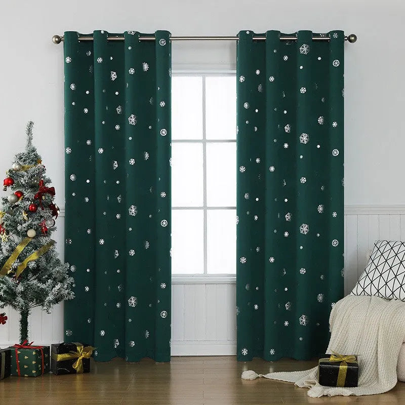 Red snowflake pattern shade cloth curtain with iron hoops hanging on a rod against a window.