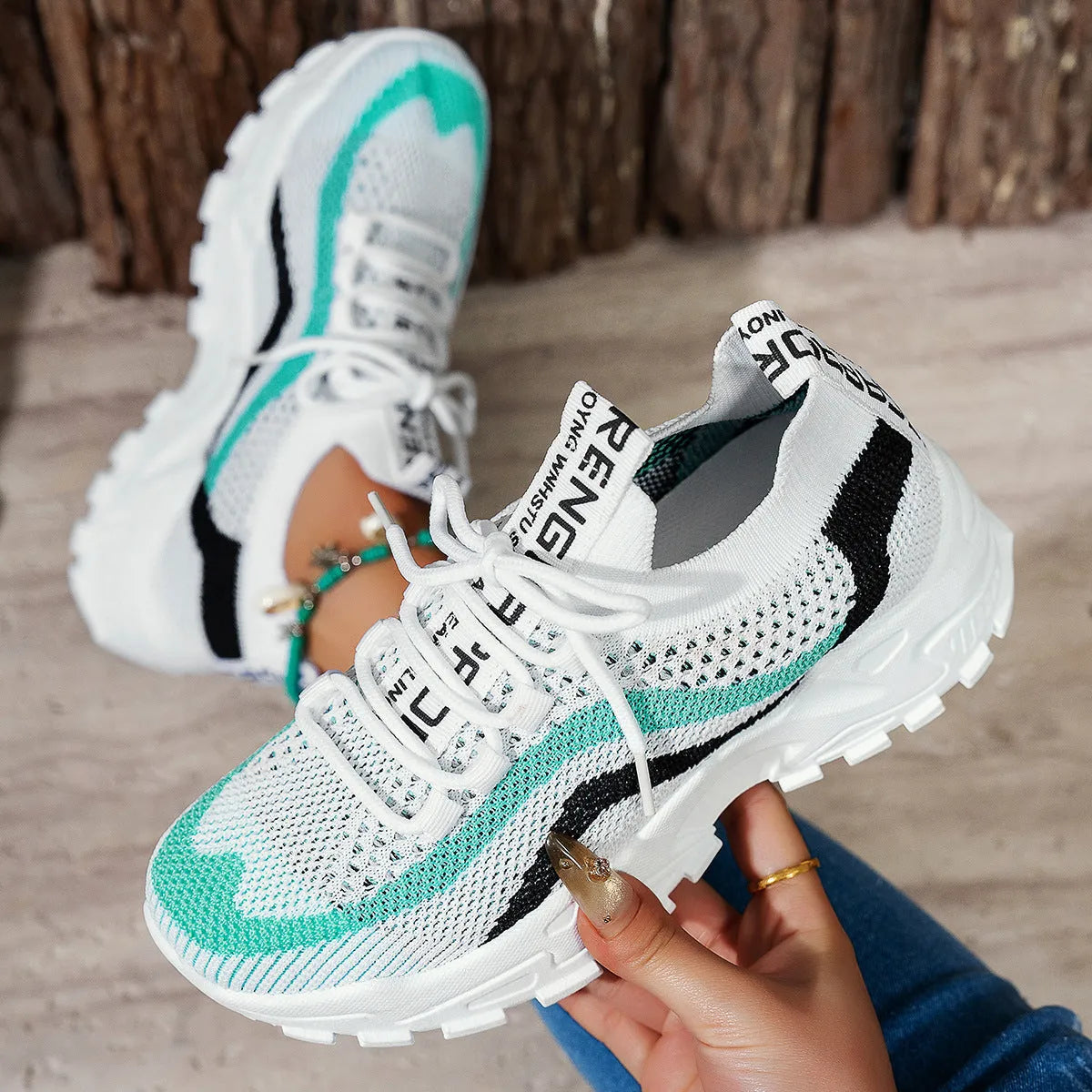 Women's casual sports shoes with mesh upper and front lace-up in black and white colour
