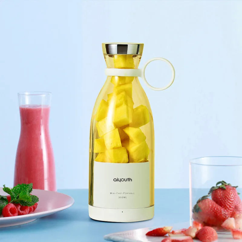 Pink and white handheld mini electric juicer with USB charging cable.