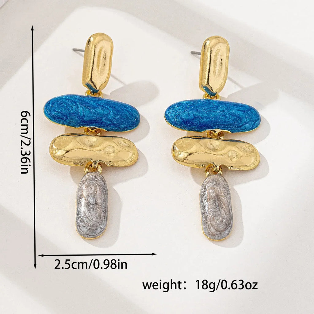 A pair of geometric multicolour stud earrings for women on a plain background.
