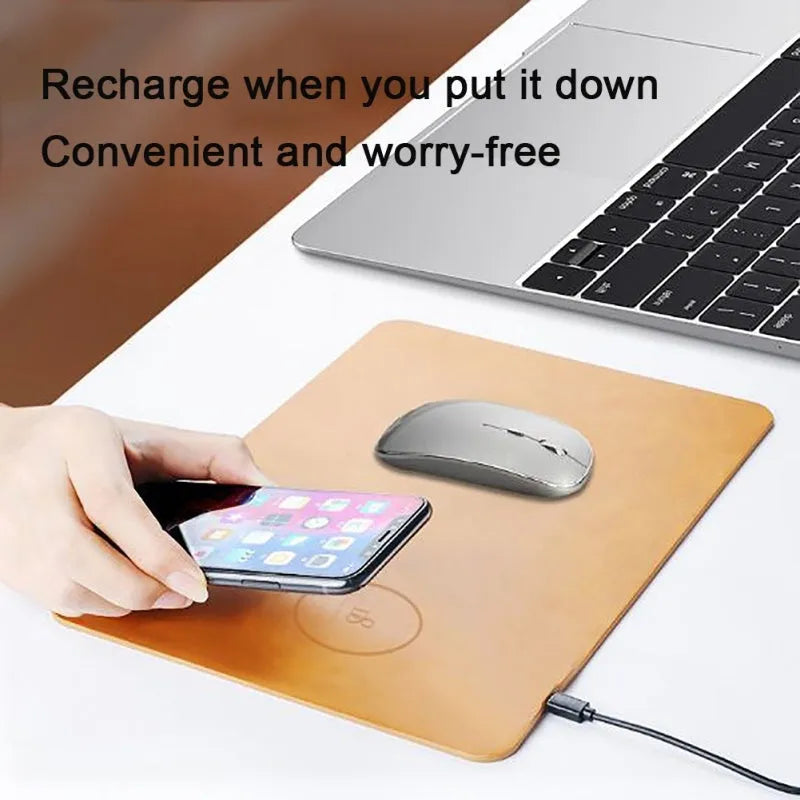 Brown leather wireless charging mouse pad with Micro USB port on a wooden desk.