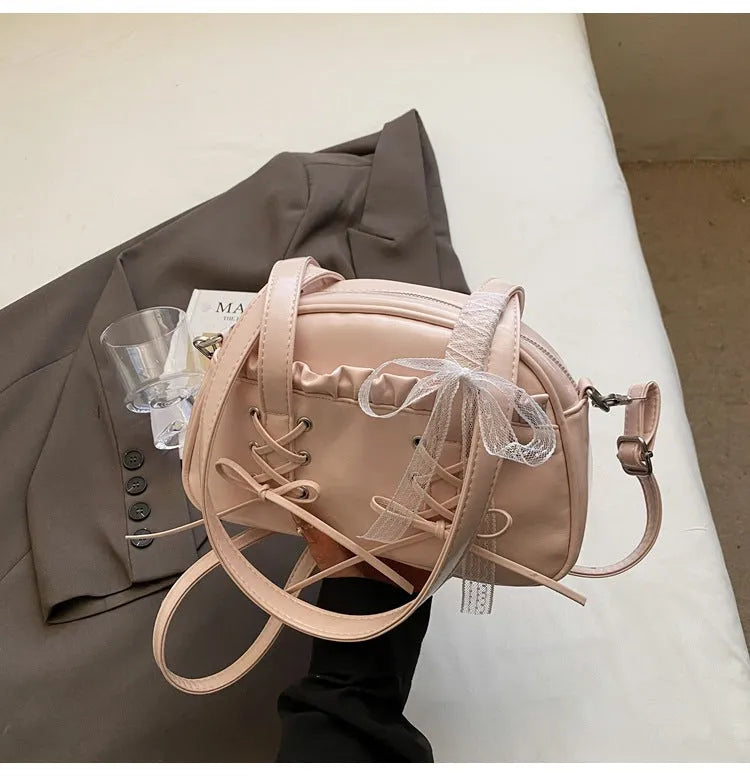 Women's PU leather handbag with bandage bow detail showing internal mobile phone pocket