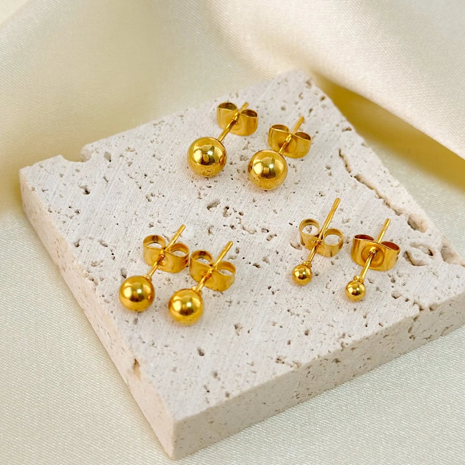 Stainless steel ball stud earrings in gold or silver finish, showing 3mm, 4mm, 5mm, and 6mm size options.