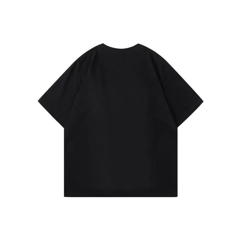 Man wearing a loose-fitting black cotton t-shirt with a white and grey patchwork letter design on the front.