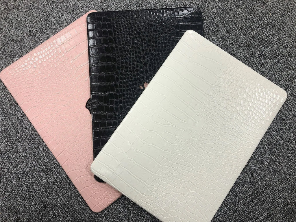 Black MacBook protective case with crocodile texture and visible Apple logo through a cutout.