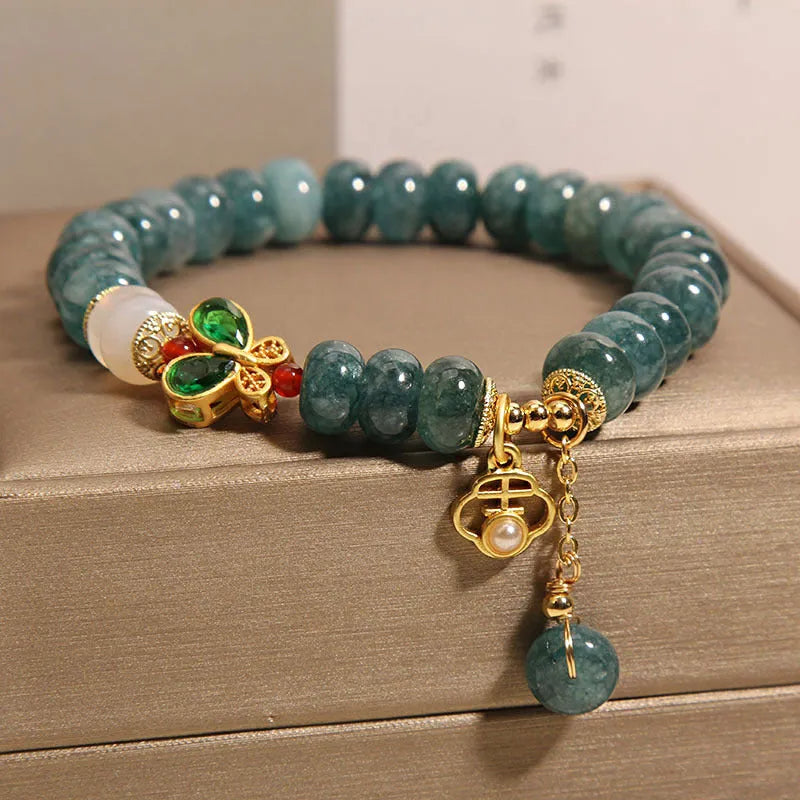 Women's blue water jade and white agate abacus bead bracelet with rhinestones and a butterfly charm on an alloy chain.