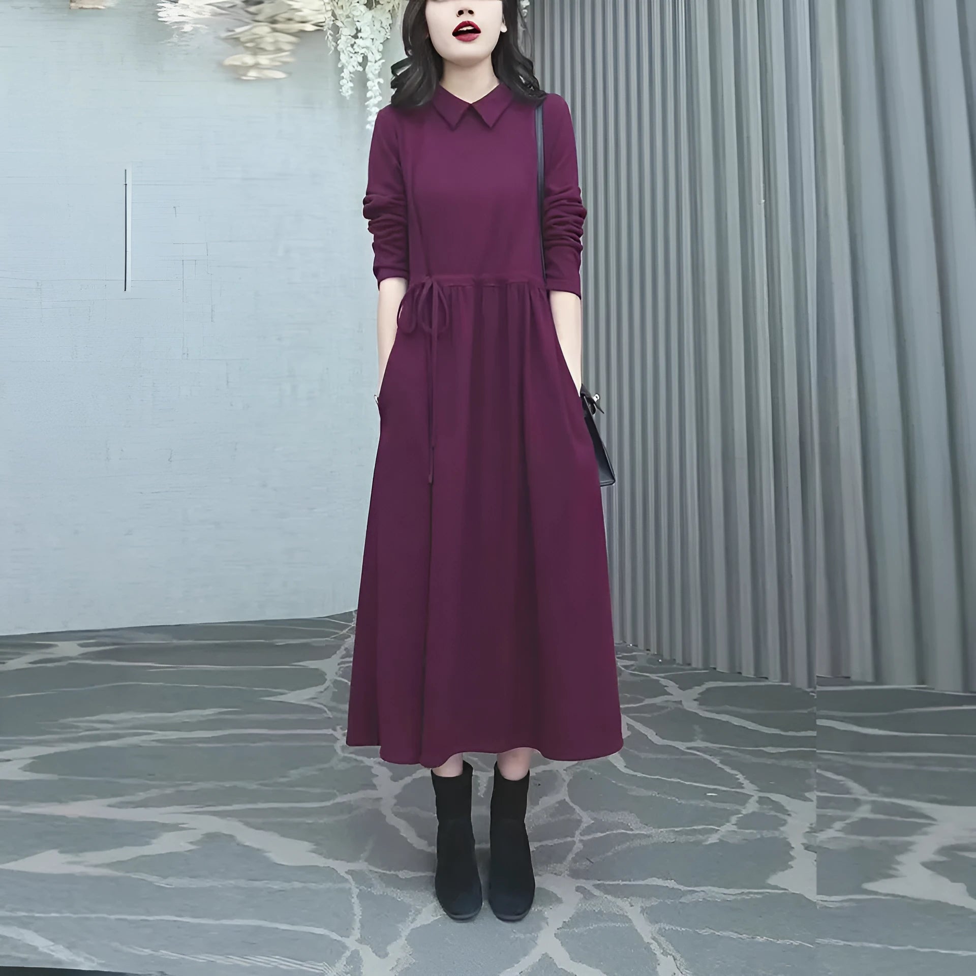A purplish red plus size long sleeve dress with an ankle-length skirt on a mannequin.