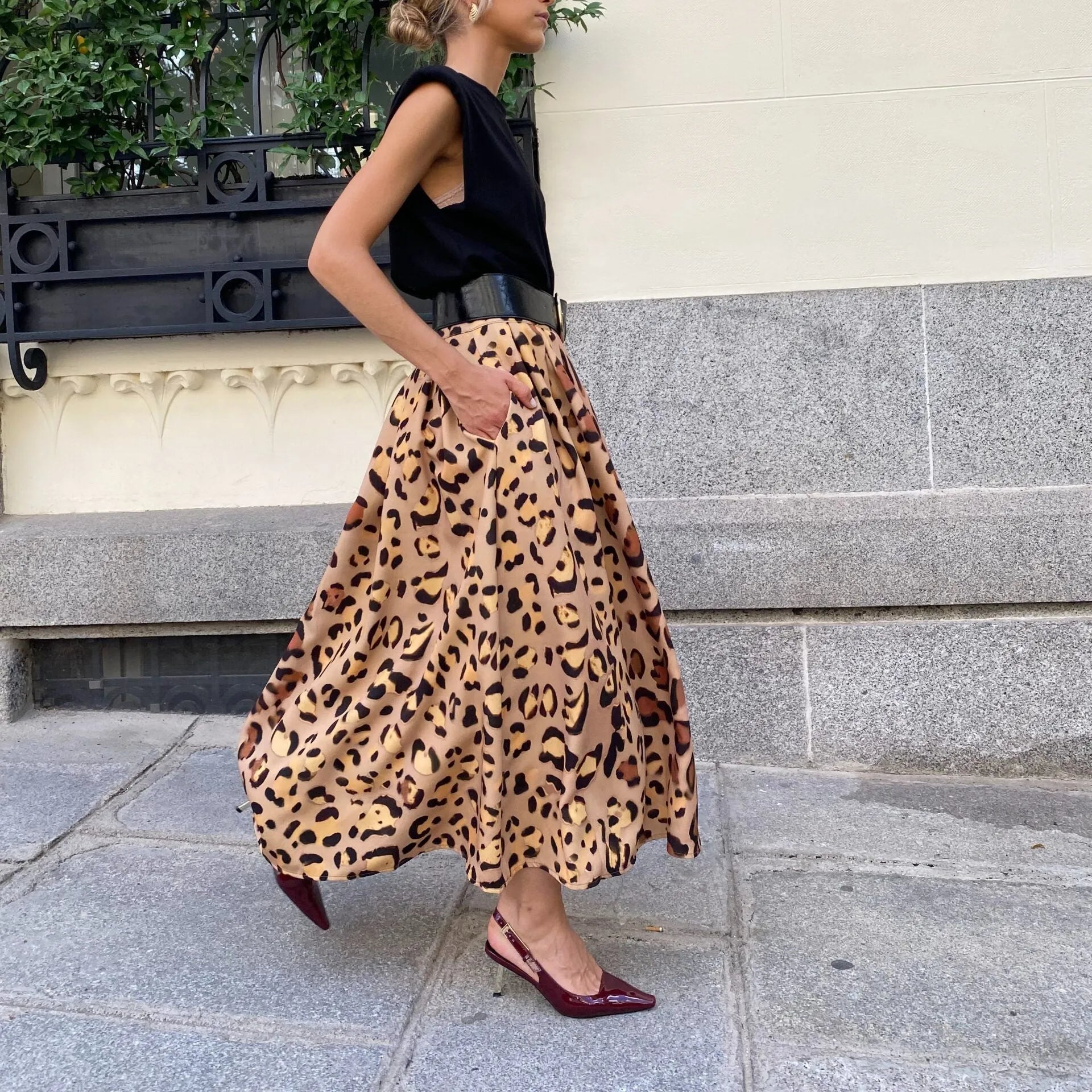 Brown leopard print women's long A-line skirt with a big hem detail on a hanger.