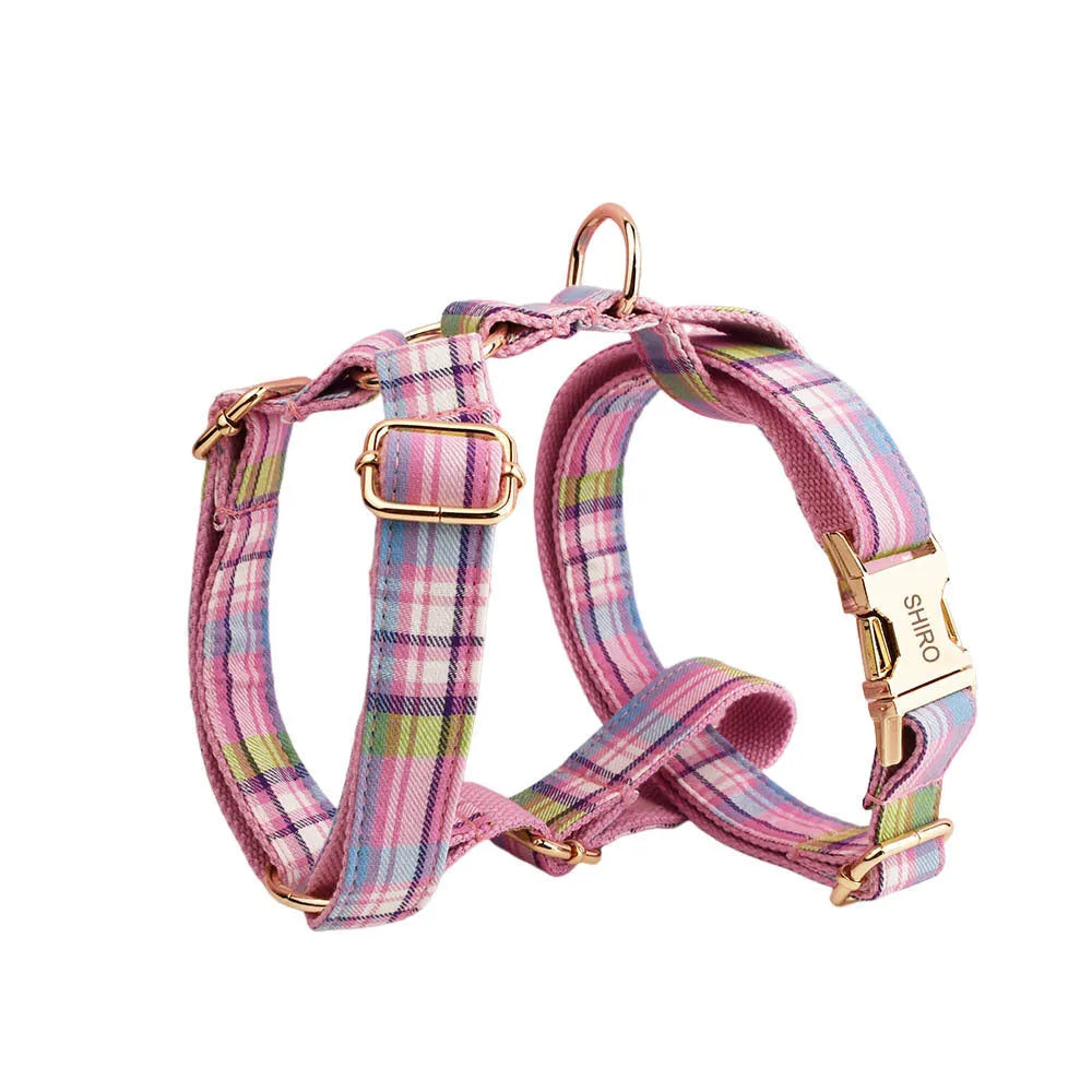 Cloth dog collar and matching lead set with a red bow and a matching dog vest laid out flat.