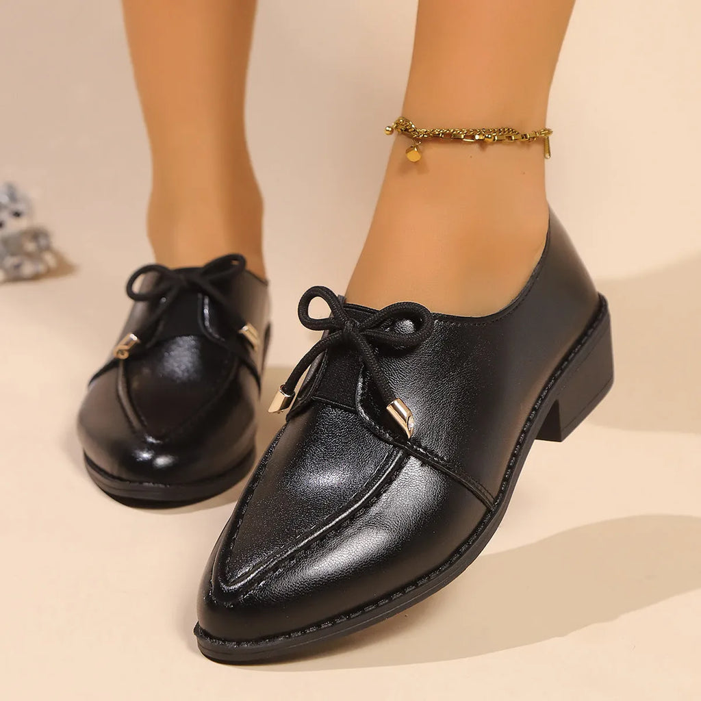 Women's beige PU leather slip-on shoes with a large bow decoration and rubber sole.