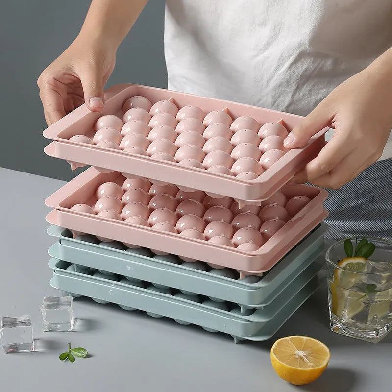 Sky blue and pink 3D round ice cube mould trays showing spherical cavities.